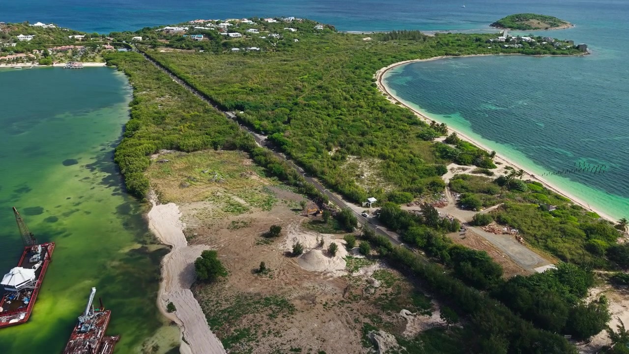 Ripresa aerea con drone della zona di Sandy Ground sull'isola di St. Martin, strada ed edifici tra il Mar dei Caraibi e la Laguna di Simpson Bay.