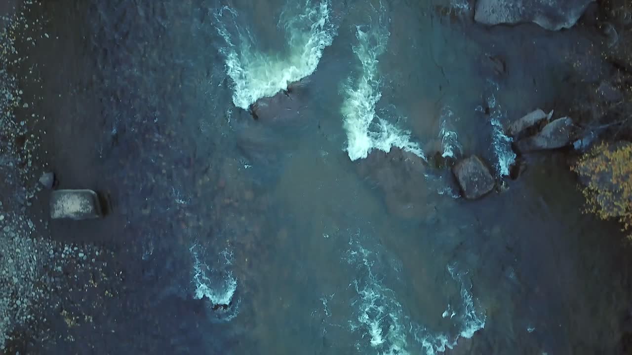 Aerial: Vertical view of flight down small river rapids in autumn