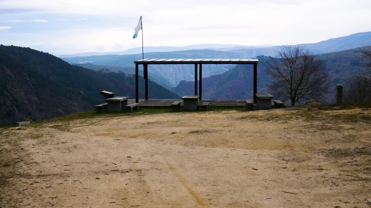 un punto de vista de la lámpara y la bandera de galicia en el borde del acantilado y al final del sendero de tierra