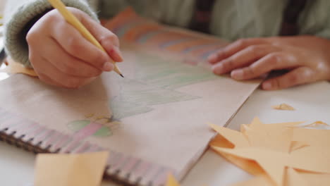 girl drawing christmas tree in album