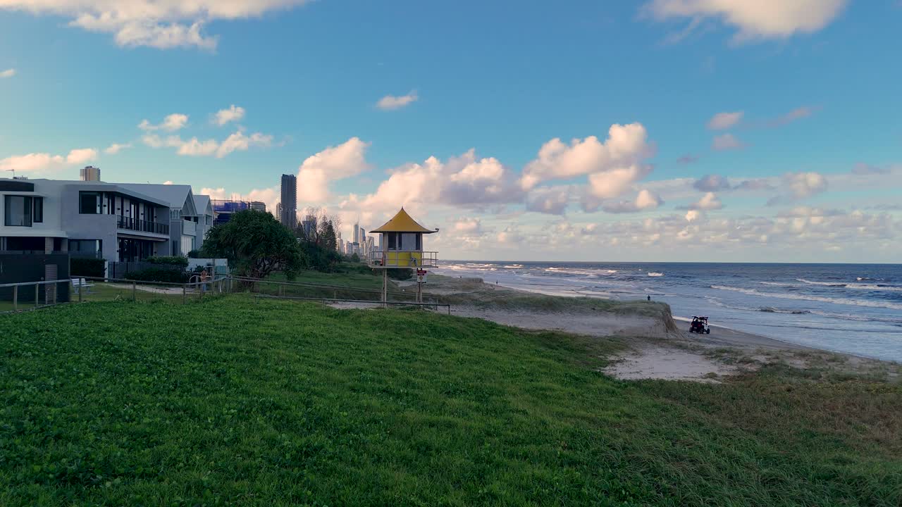 Aerial footage of a lifesaving patrol tower on Gold Coast beach, showcasing coastal scenery and vibrant skies