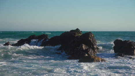 las olas golpean las rocas en cámara lenta
