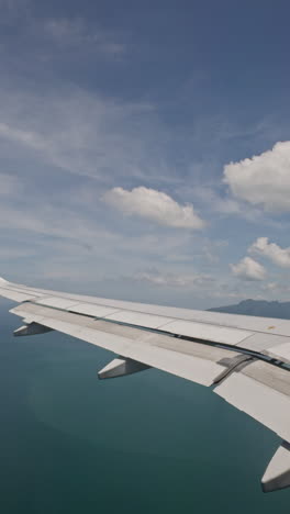 view from a plane window of the sky with the wing shot in vertical
