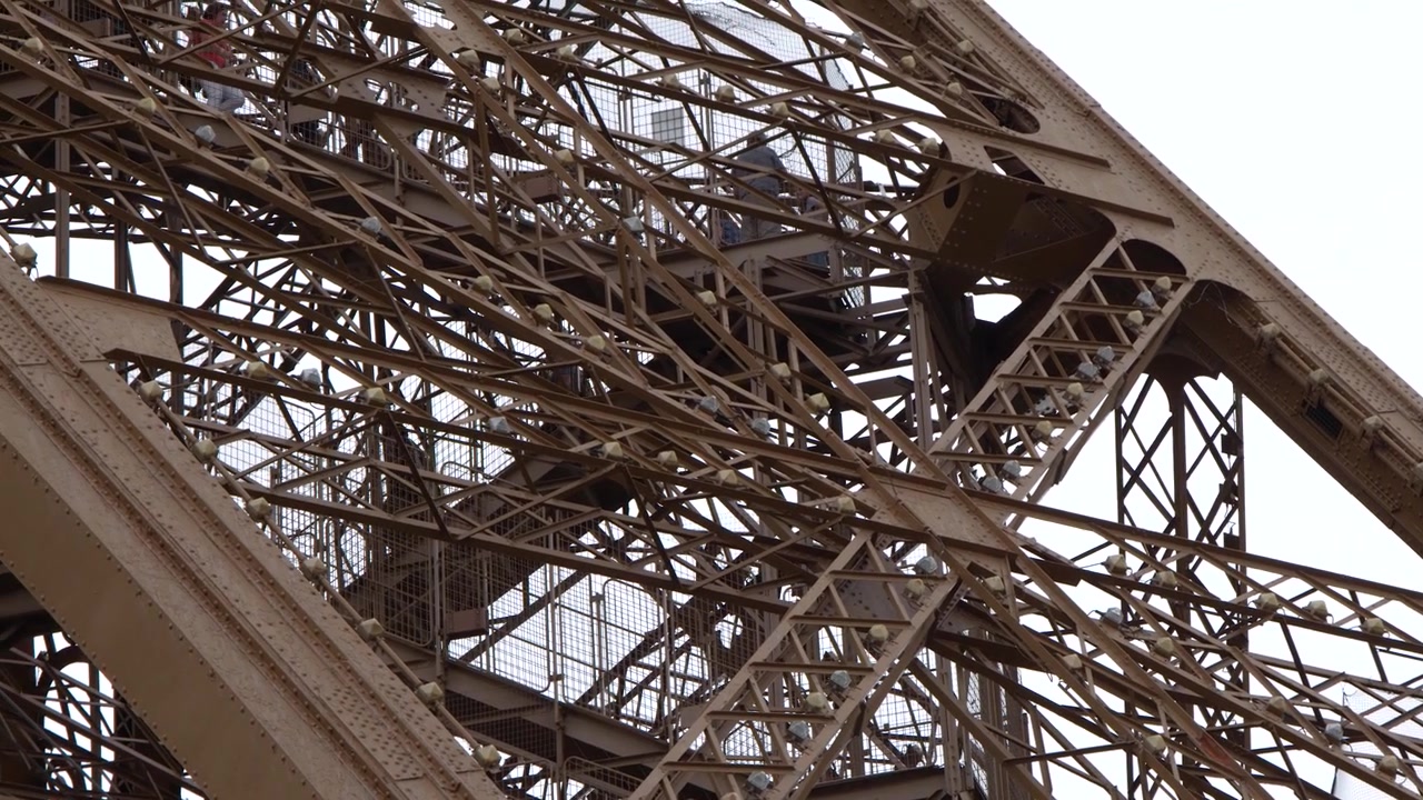 Static medium shot of the intricate metal framework and architectural details of the Eiffel Tower
