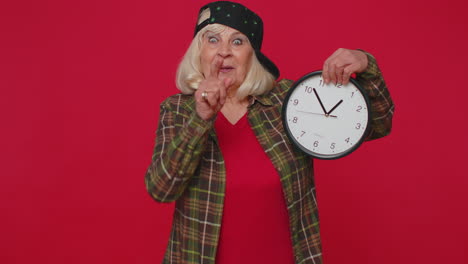 Elderly-senior-woman-showing-time-on-clock-watch,-ok,-thumb-up,-approve,-pointing-finger-at-camera