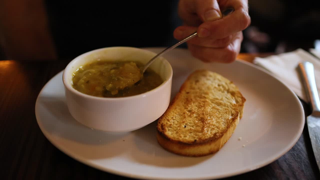 Person enjoying soup with bread in Fife