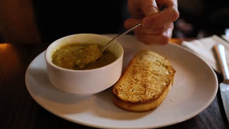 person enjoying soup with bread in fife