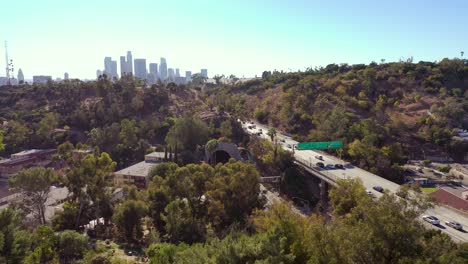 aerial freeway cars travel along the 110 freeway in los angeles through tunnels and towards downtown skyline