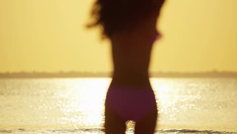 chica china asiática descalza bailando despreocupada en la playa