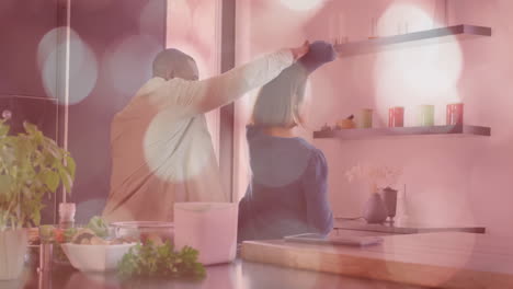 bokeh light animation over couple cooking together in modern kitchen