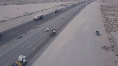 Imágenes-Aéreas-Del-Tráfico-De-La-Carretera-Del-Desierto---Volar-Hacia-Atrás