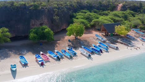 Blue-wooden-boats-on-beach-at-Cueva-de-los-Pescadores,-Pedernales