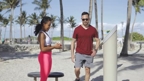 woman training sporty man on beach