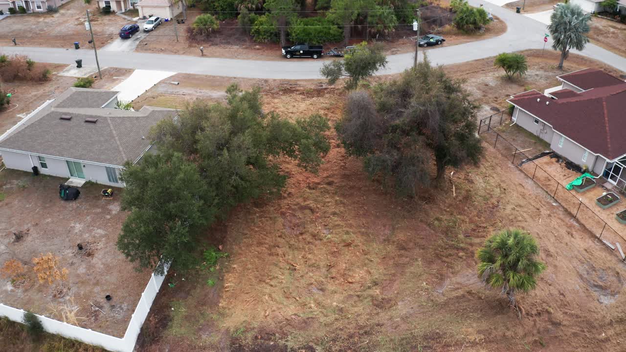 Un terreno arbolado rodeado de viviendas residenciales y una carretera sinuosa. Ideal para análisis inmobiliarios o visualizaciones de planificación urbana.