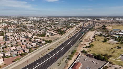 drone panning around highway next to residential houses and park