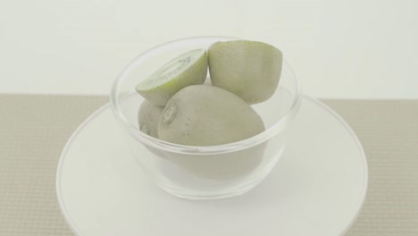 kiwis verdes frescos y maduros en cuenco giratorio, no clasificados