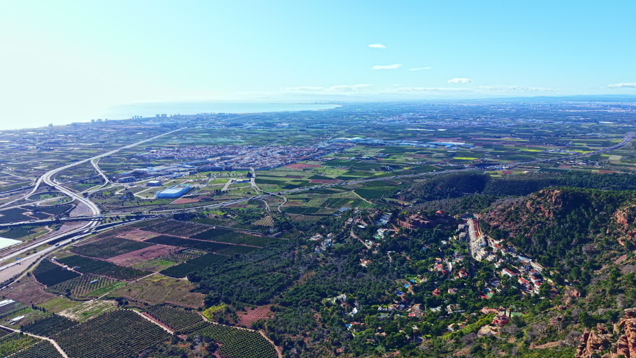 在廣闊的區域，日間可見一幅風景，其中包含綿延的田野、道路，以及遠方依海而建的城市。