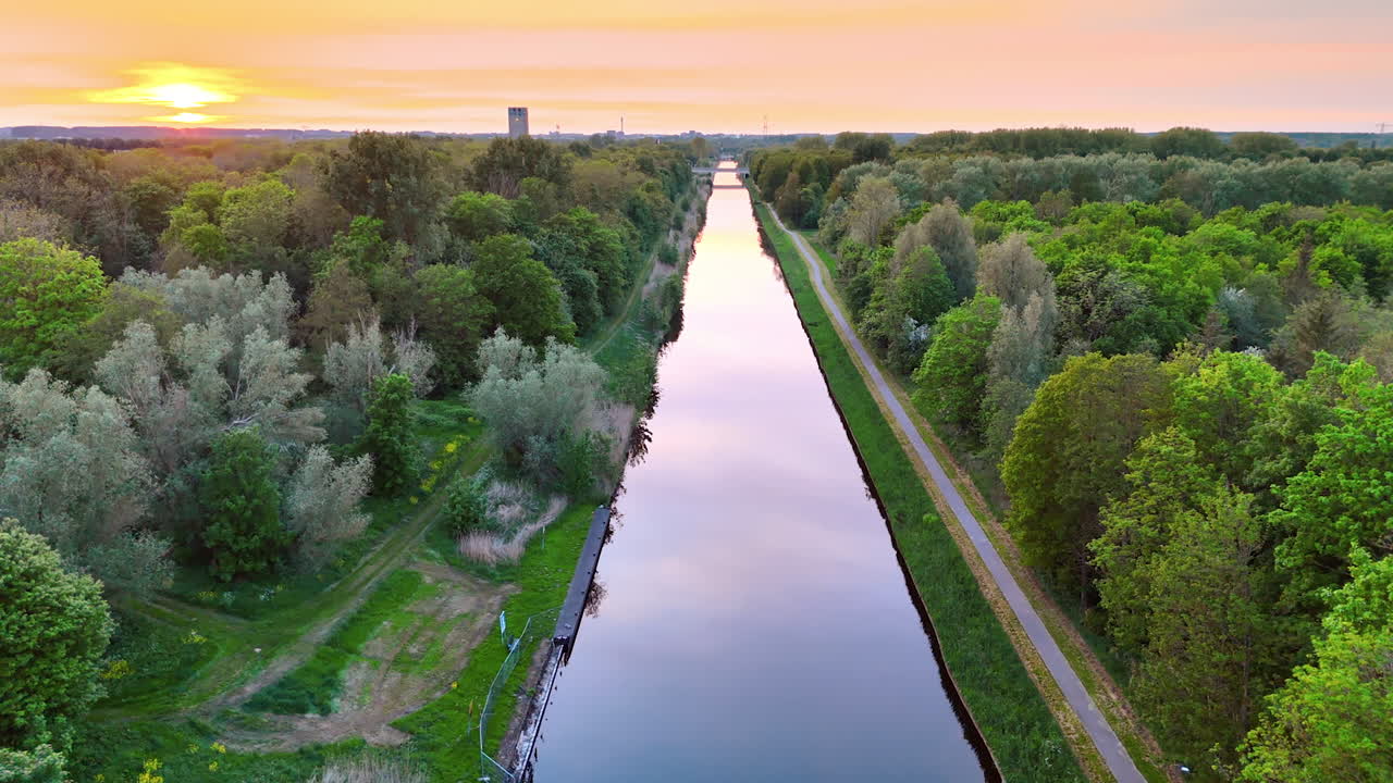 Serene sunset by the river. A serene sunset reflects on a calm river lined with dense trees, showcasing nature's beauty in tranquility