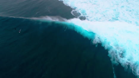 drone top down tracking follows crashing wave and whitewash at cloudbreak fiji