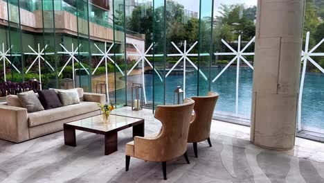 luxurious living room with taped windows overlooking pool during rain storm