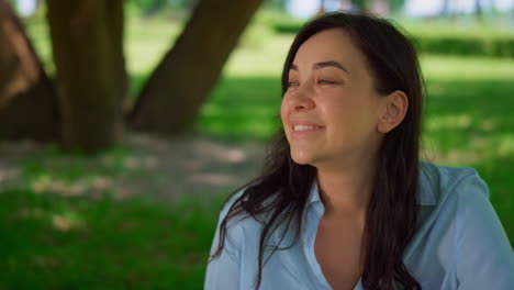 retrato de una mujer sentada en un prado de cerca. madre feliz descansando al aire libre.