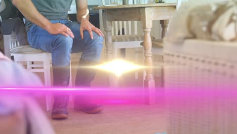 animation of light over low section of man in kitchen wearing wellington boots