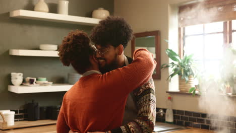 a young couple hugging in the kitchen