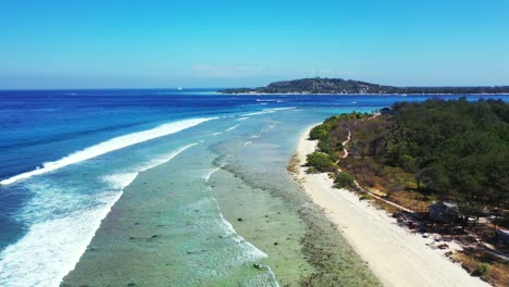 Küstenmuster-Aus-Korallenriffen-Und-Felsigem-Meeresboden,-Bedeckt-Von-Weißen-Wellen,-Die-Aus-Dem-Blauen-Meer-Kommen,-An-Einem-Sonnigen-Morgen-Mit-Klarem,-Hellem-Himmel-In-Indonesien