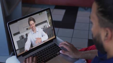 hombre de oriente medio teniendo una videollamada con un colega masculino en una computadora portátil