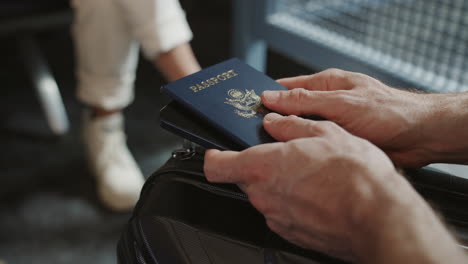 close up on hands holding passport while waiting to board international flight in airport terminal or gate