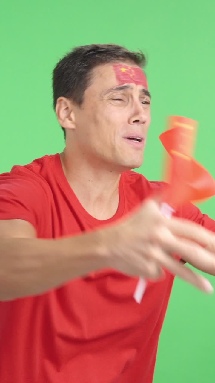 Nervous man cheering for China during a match looking away