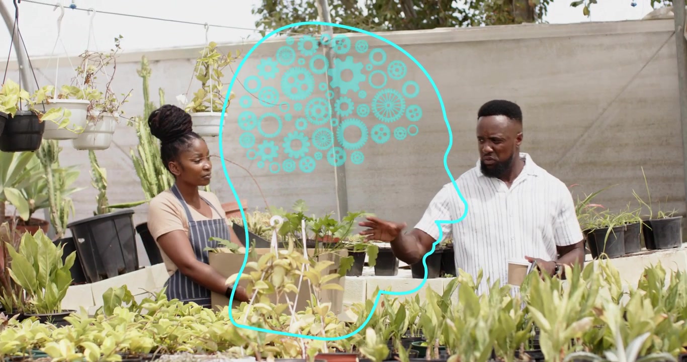 Vendor presenting plant box toward customer in nursery, driving selection discussion over phone