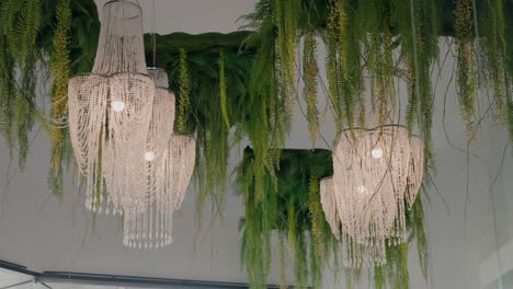 elegant crystal chandeliers and lush greenery hanging from the ceiling