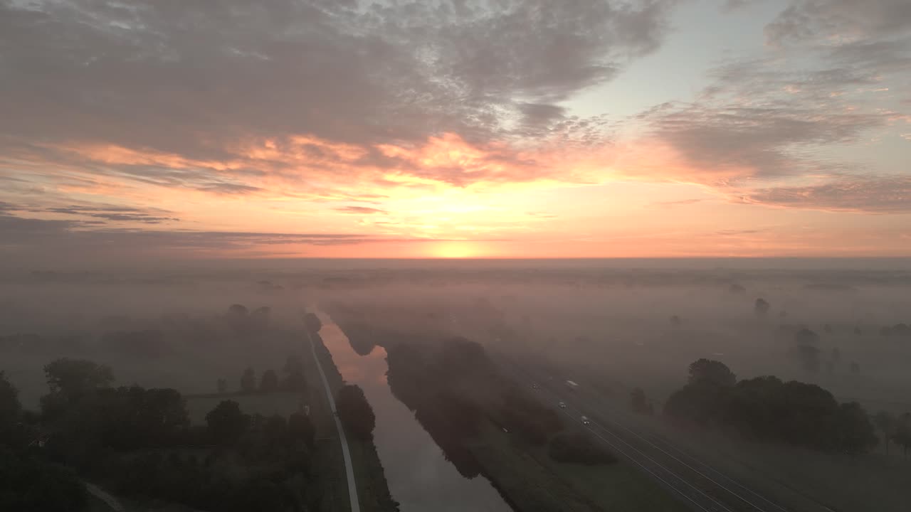 amanecer sobre el paisaje nebuloso con canal y carretera