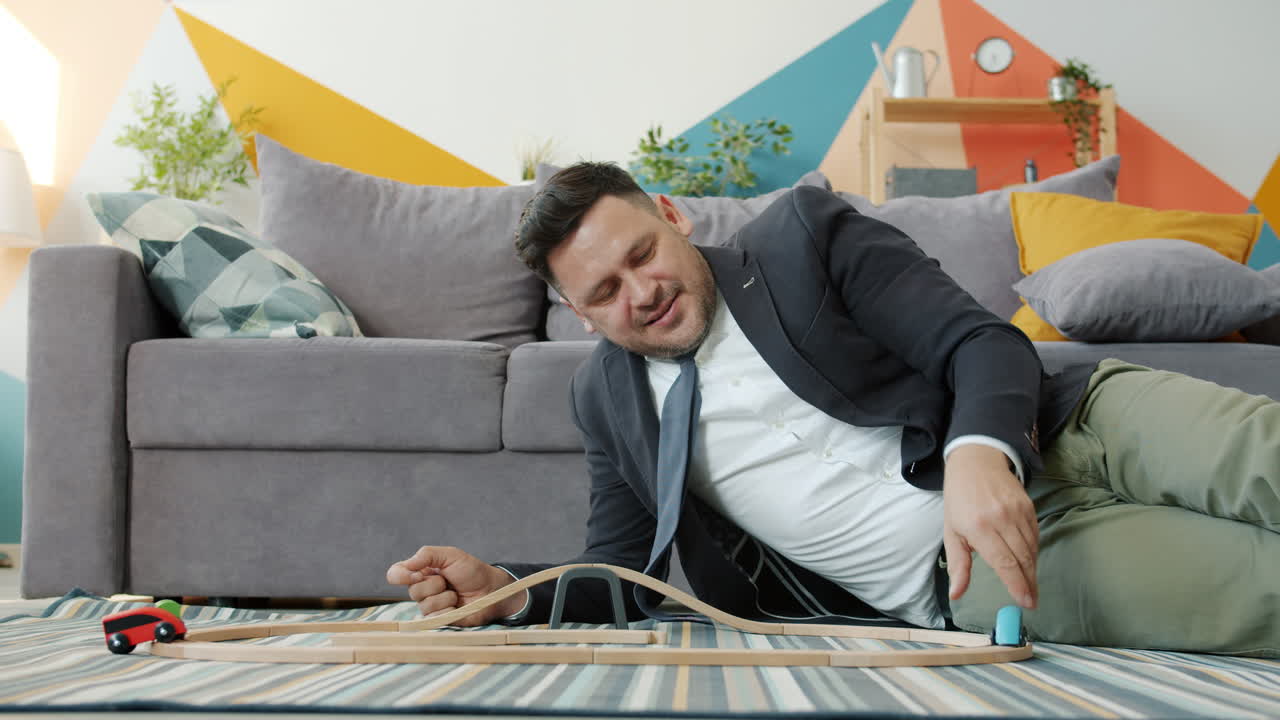 Businessman Playing with Toy Cars at Home