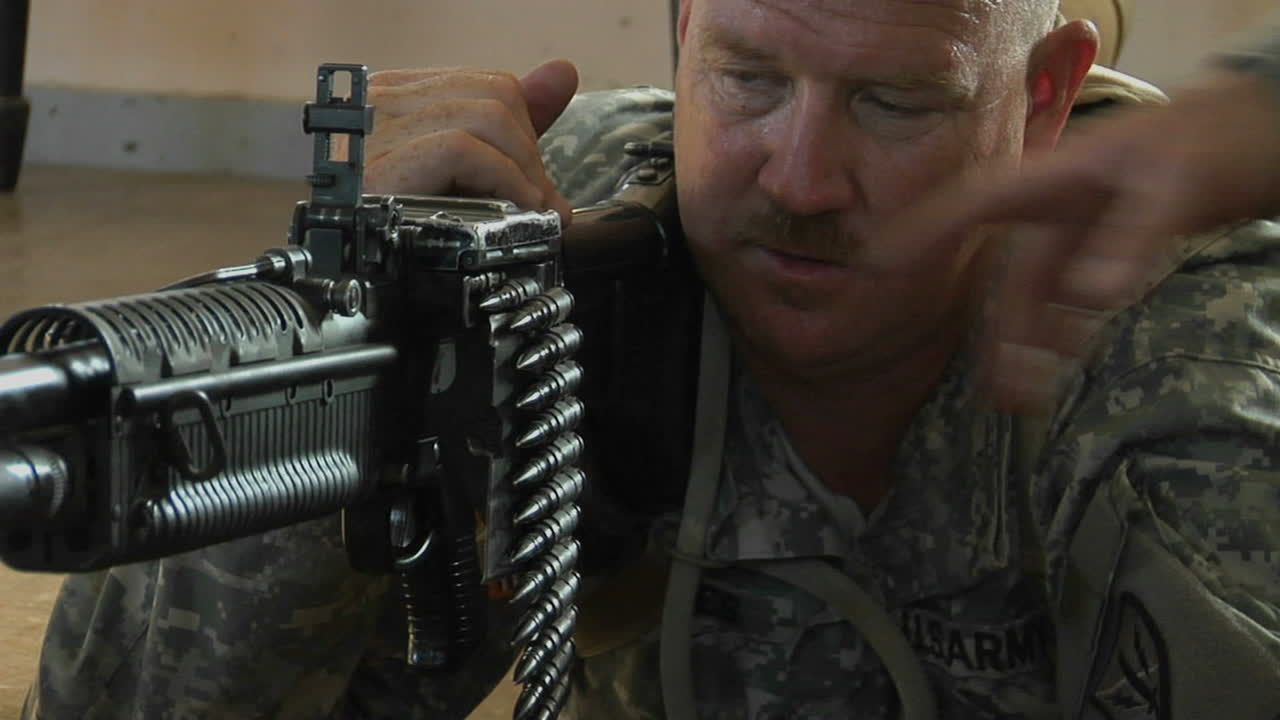 мужчина готовится к стрельбе из автоматического оружия