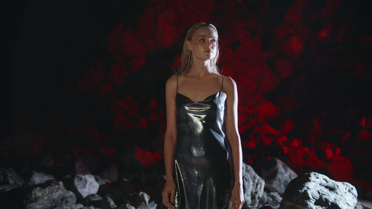 멋진 모델이 밤에 해변에서 포즈를 취하고 있습니다. 섹시한 금발 모양의 카메라가 만지고 있습니다.