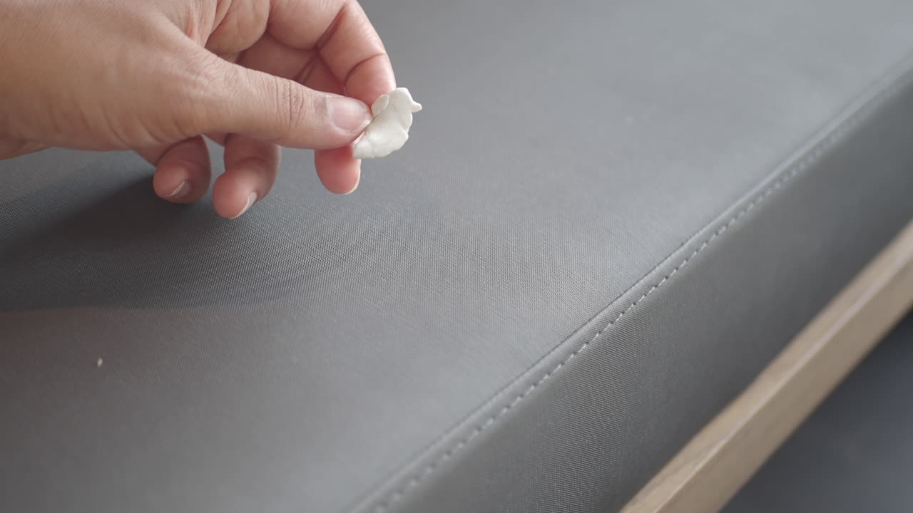 la mano recogiendo chicle de una superficie gris