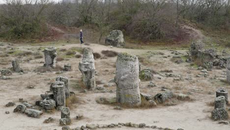 Lonely-woman-walks-slowly-in-solitude-in-ancient-rock-formations-Pobiti-Kamani