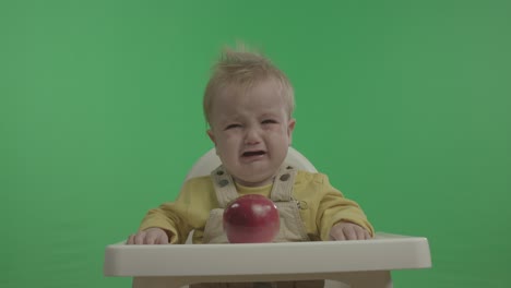 happy baby having fun and playing with apple.