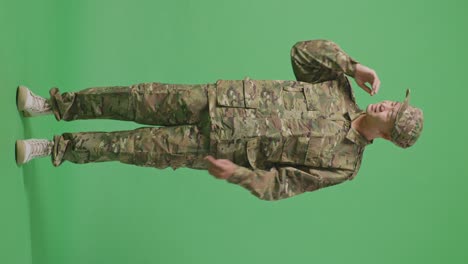 full body of asian man soldier wiping the sweat and being tired while standing in the green screen background studio
