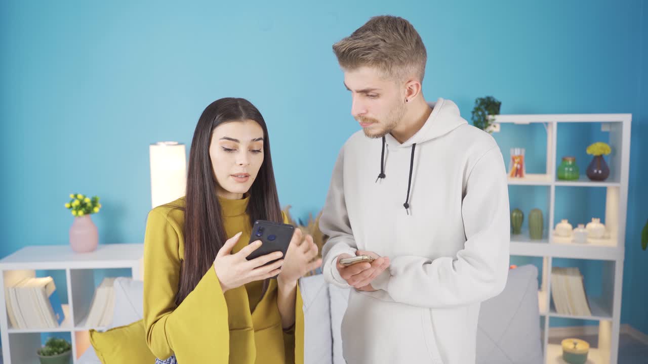 joven novio y novia hablando mirando el teléfono, discutiendo sobre un tema.