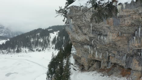 flying towards icicles hanging of rock mountain wall