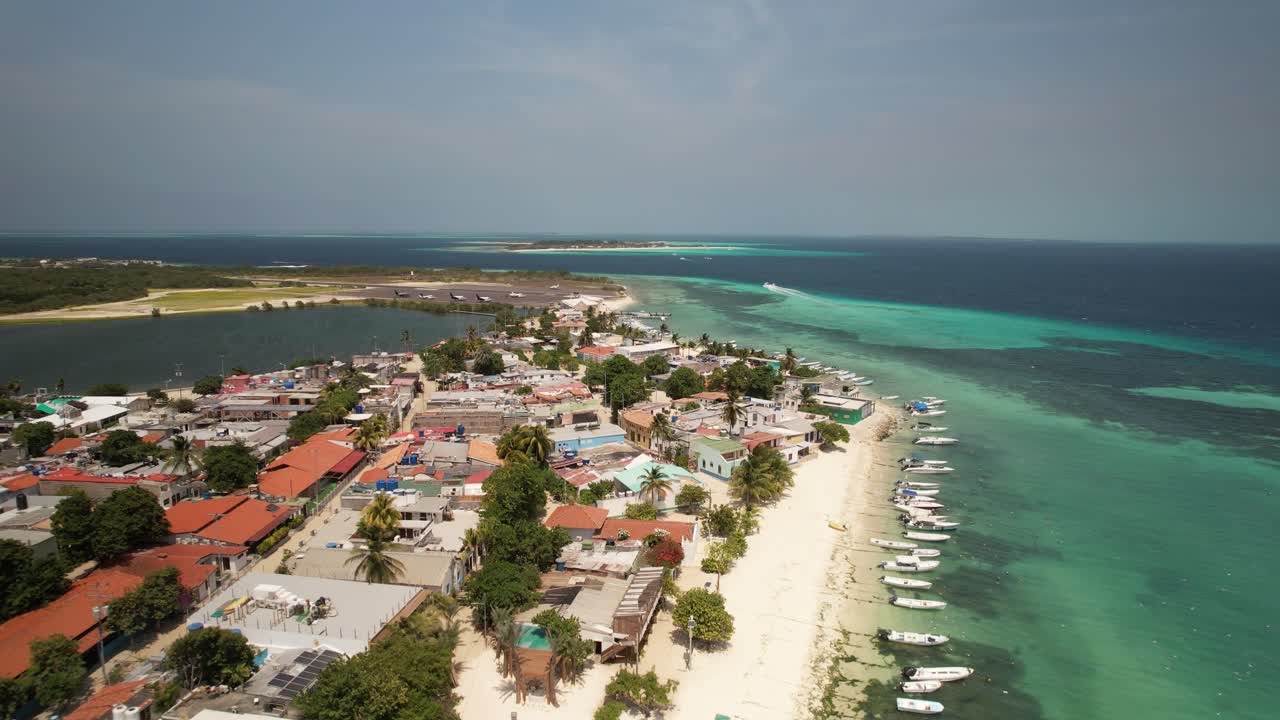 los rocas, venezuela, mostrando un pueblo junto a la playa y barcos atracados a lo largo de la costa, vista aérea