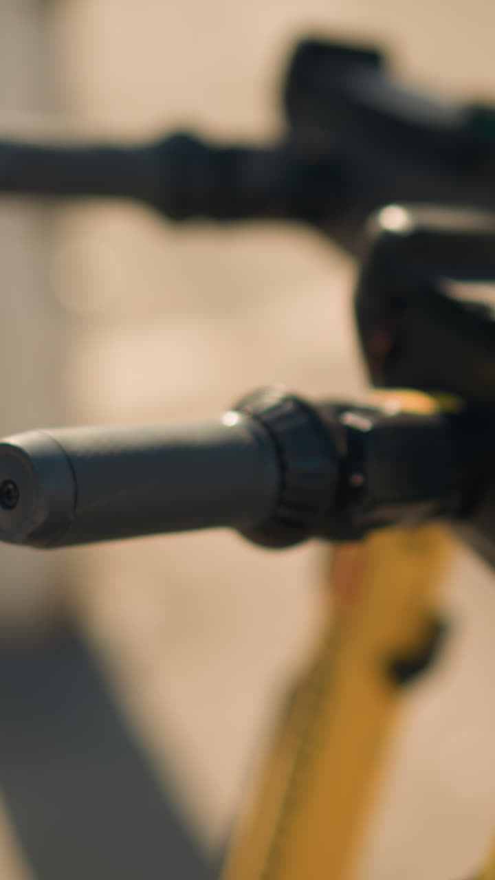 Primer plano de una fila de puños de scooter que muestran manillares alineados y estructuras amarillas en un muelle a la cálida luz del sol. La animada escena urbana sugiere una cola de viajeros, una revisión de mantenimiento, una recogida de turistas y sostenibilidad.