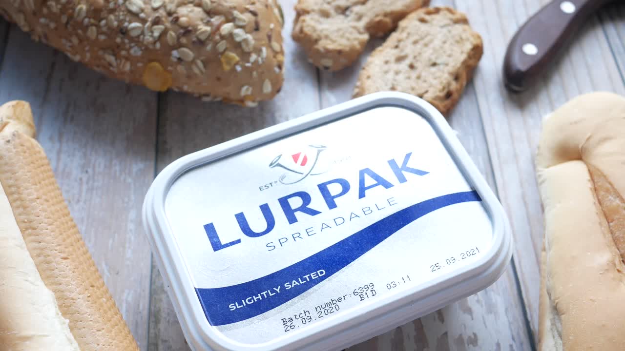 pan, mantequilla y baguettes en una mesa de madera