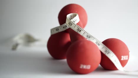 male hand grabs an apple and bites a piece off then places it next to red dumbbells, slomo