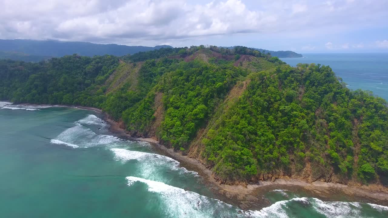 Drone shot overlooking the lush green hills of Playa Herradura in Costa Rica on a cloudy day in paradise