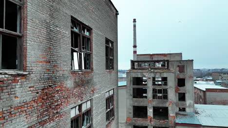 old brick and concrete premises of an abandoned factory. huge industrial territory with ruined constructions at the backdrop of a city.