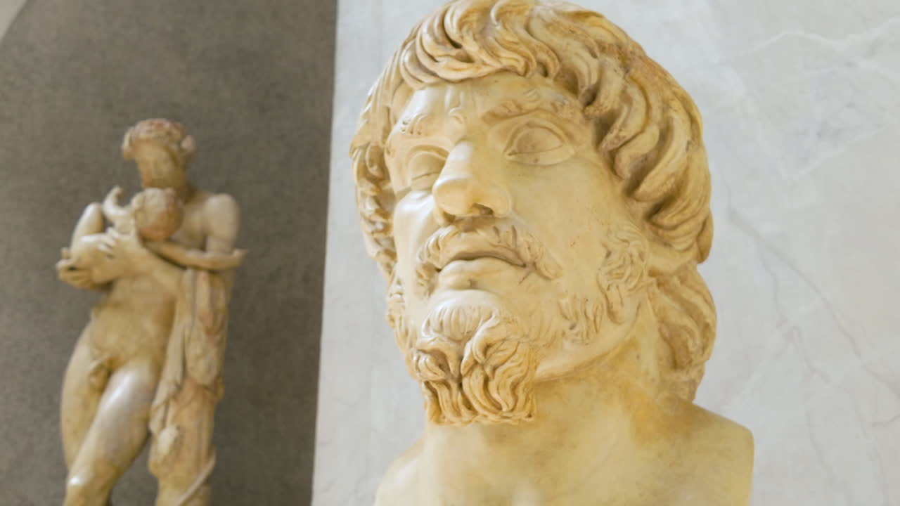 Detailed Roman bust of a bearded man displayed in a marble interior of a museum.